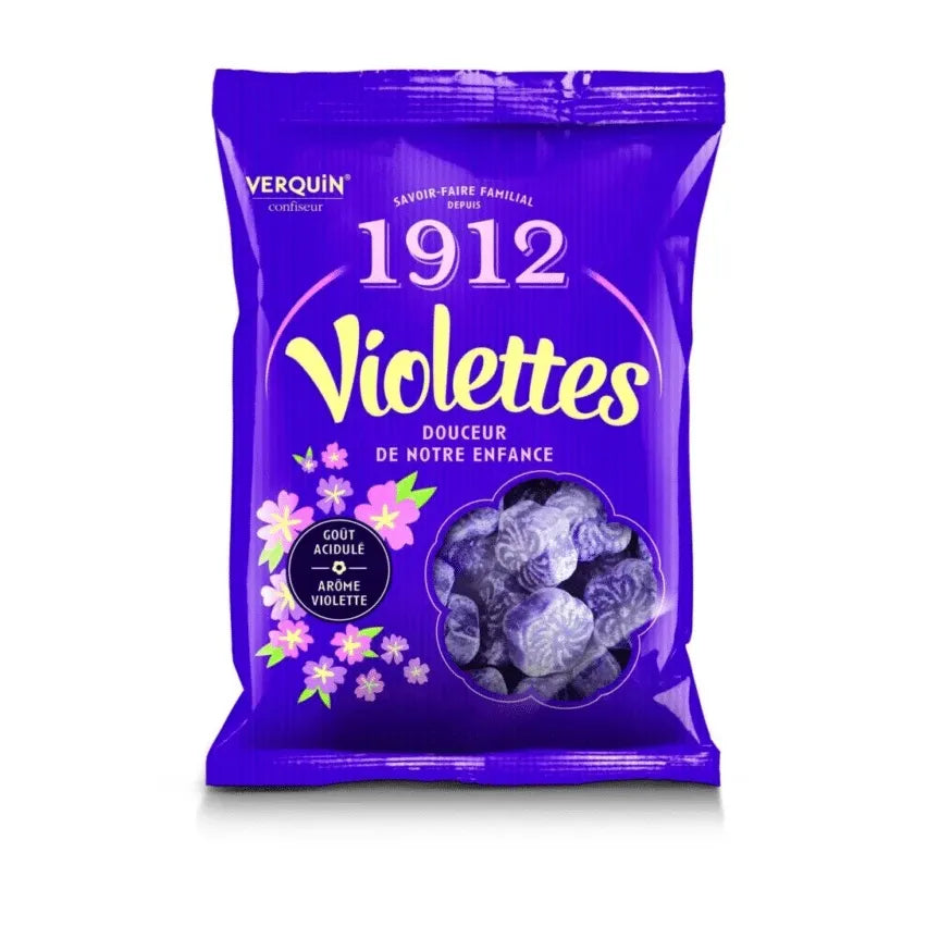 A 150g purple bag of Twice as Sweet Verquin Violette Bonbons (France) featuring floral designs, French text, and an image of sugared, violet-shaped candies.