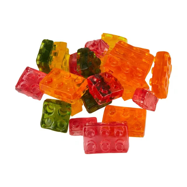 Twice as Sweet Amos 4D Fruit Gummy Blocks 150g (China) in red, orange, yellow, and green—shaped like toy building blocks—are arranged on a white background.