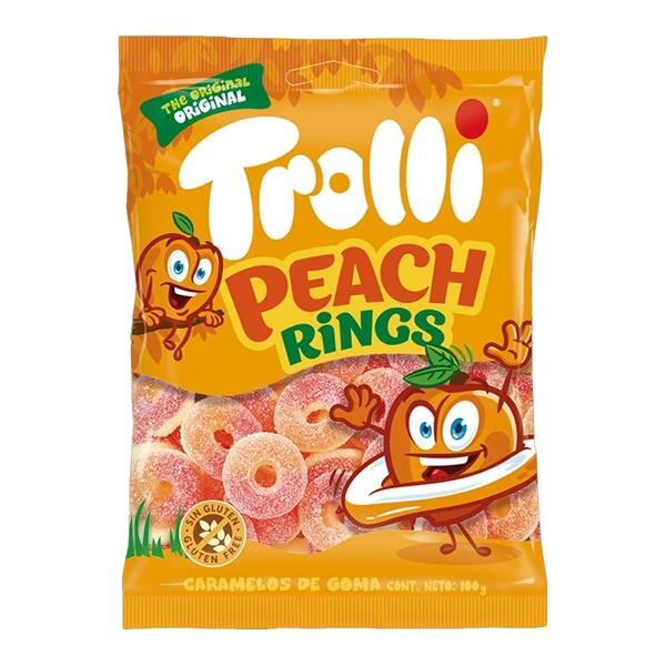 A 100g bag of Twice as Sweet Trolli Peach Rings (Spain) features orange packaging with cartoon peaches, Trolli Peach Rings text, and a clear window showing sugar-coated peach gummies—ideal for sour candy fans.