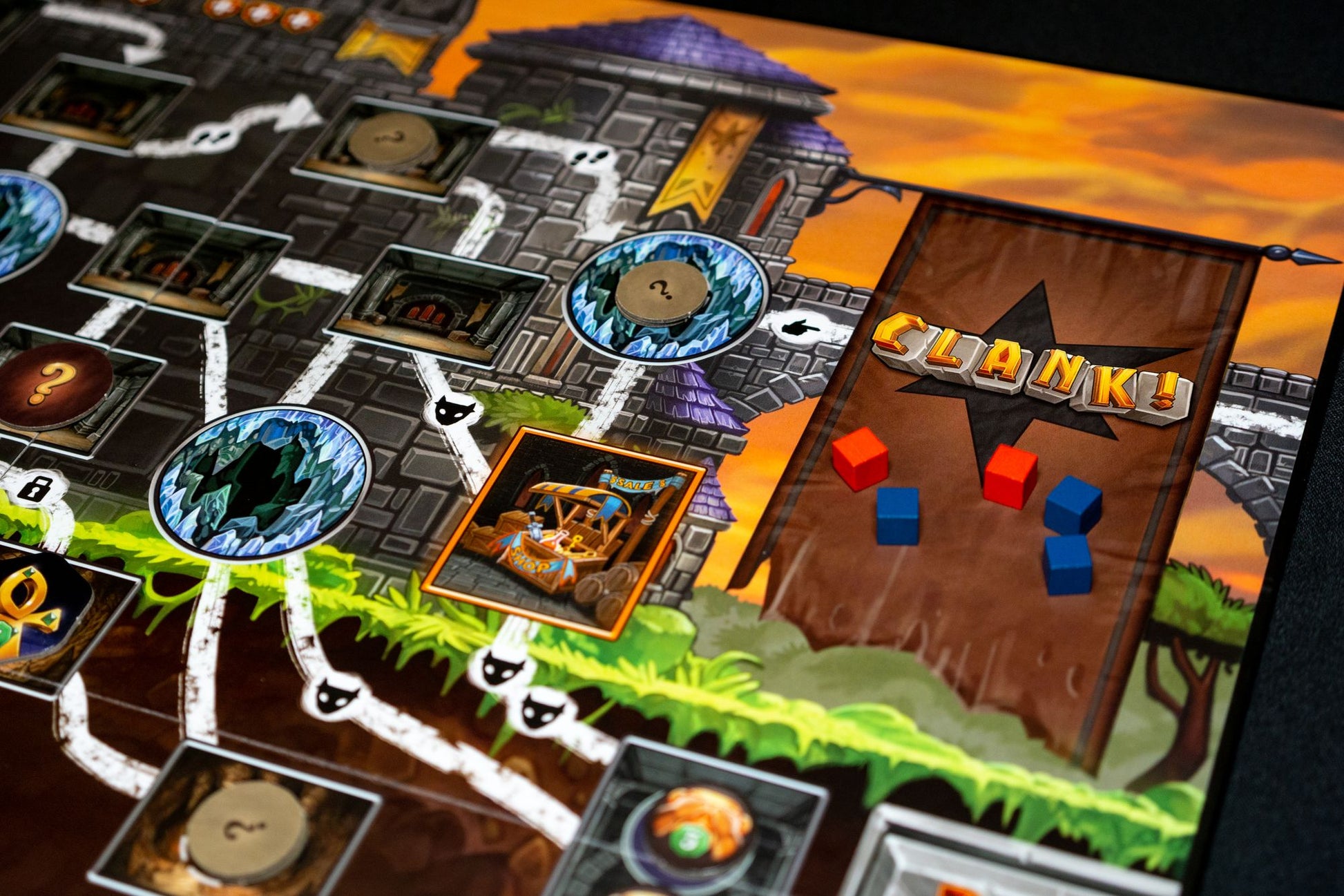 Board game setup with 'Clank!' logo on a themed playing mat for the board game Clank! a Deck Building Adventure