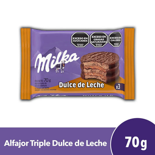 Twice as Sweets Milka Dulce De Leche Alfajor 70g (Argentina) features three chocolate-covered layers with creamy dulce de leche filling in a purple package, and carries warnings for excess sugars, fats, and calories.