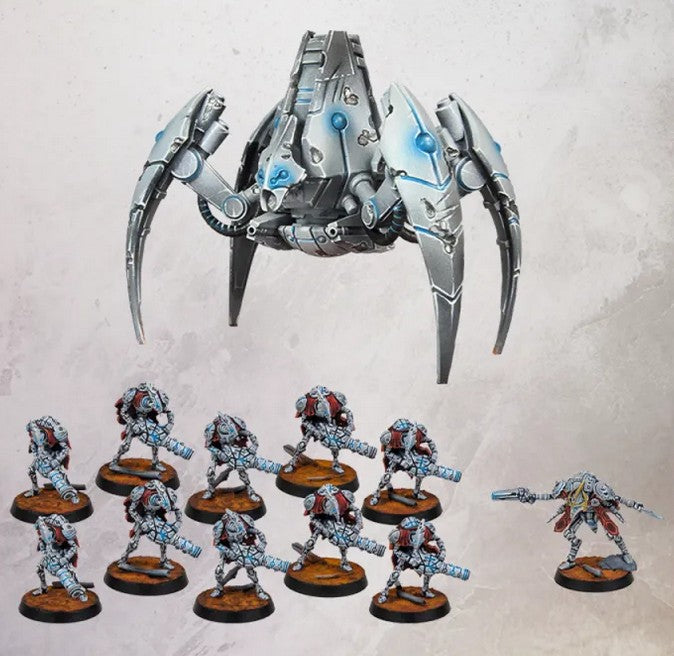 A tabletop display of painted sci-fi miniature figures and a large robotic spider-like model on a textured light background. The set includes one large metallic gray and blue machine figure at the top, several small armored infantry figures with brown bases across the bottom, and one smaller figure on the right. All products are the contents of One Page Rules Grimdark Future Robot Legions Vanguard Expansion