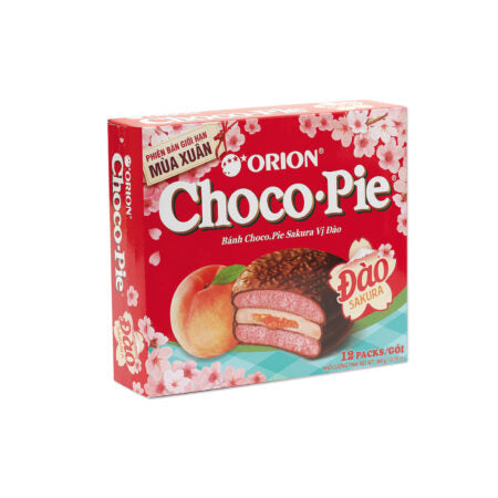 A red box of Twice as Sweet Orion Choco Pie Sakura Peach 12 Pack (Vietnam) features peach and cherry blossom designs, with 12 individually wrapped pink cream-filled chocolate pies inside.