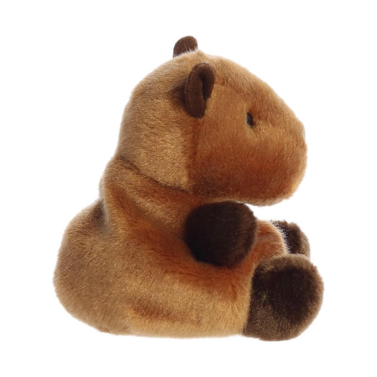 The Twice as Sweet Palm Pal Sid Capybara plushie is a soft, brown capybara with darker paws, ears, and nose, shown sitting upright in profile against a white background—a perfect zoo animal addition to any collection.