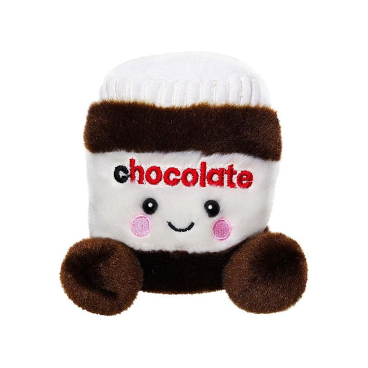 The Twice as Sweet Palm Pal Silky Chocolate Spread is a plush toy shaped like a jar with a white lid, brown and white body, embroidered chocolate text, rosy cheeks, a smiley face, and fuzzy round feet and hands.