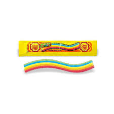 A yellow Twice as Sweet wrapper lies above a colorful Chupa Chups Sour Rainbow Jelly Belt (7g, Vietnam) with blue, yellow, and pink layers on a white background.