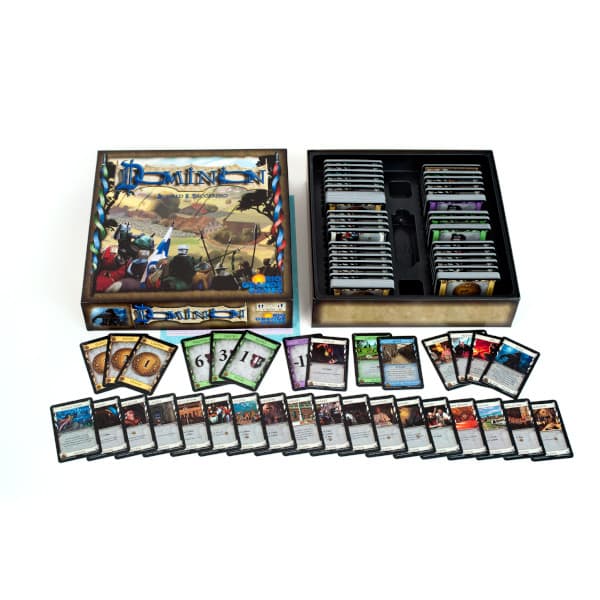 Board game contents for Dominion Second Edition with cards and box on a white background