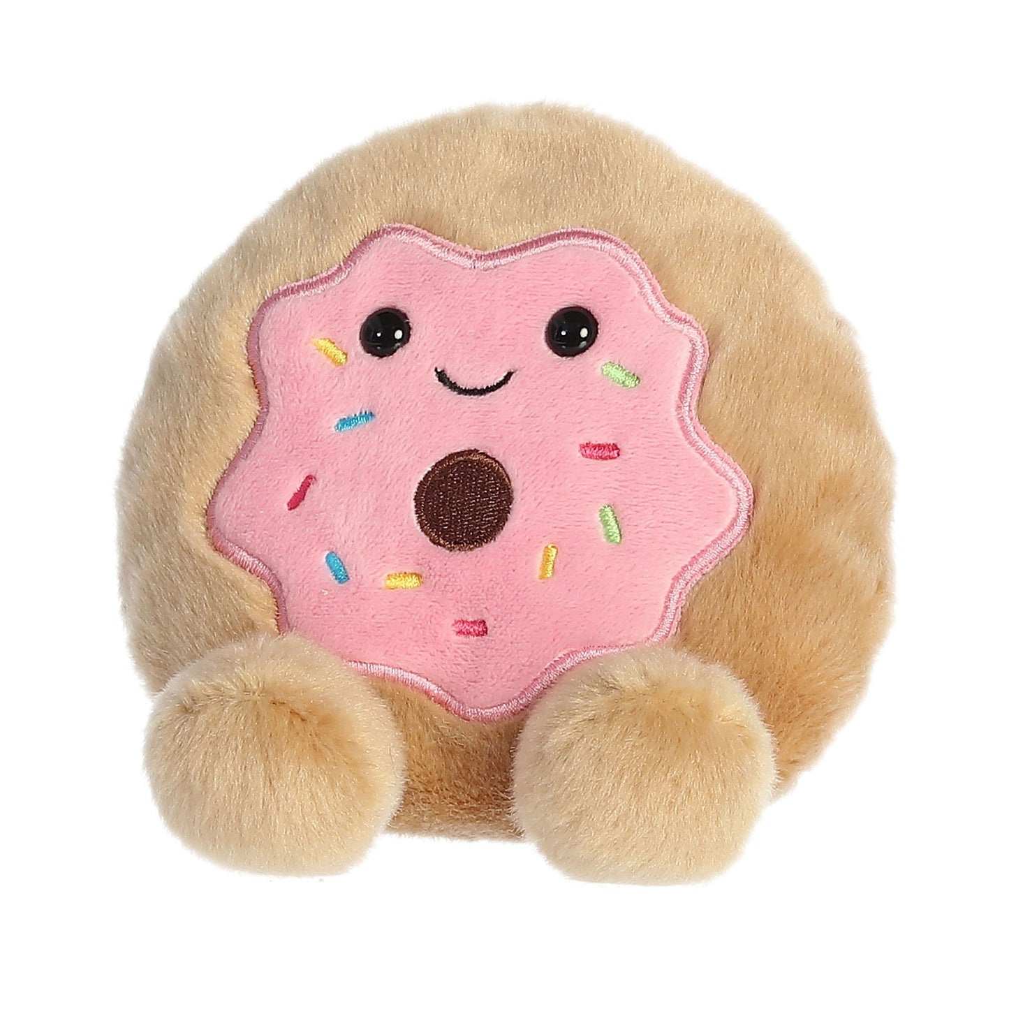 Meet Palm Pal Claire Donut by Twice as Sweet, a plush toy shaped like a donut with pink frosting, colorful sprinkles, a smiling face, and two round fluffy feet.