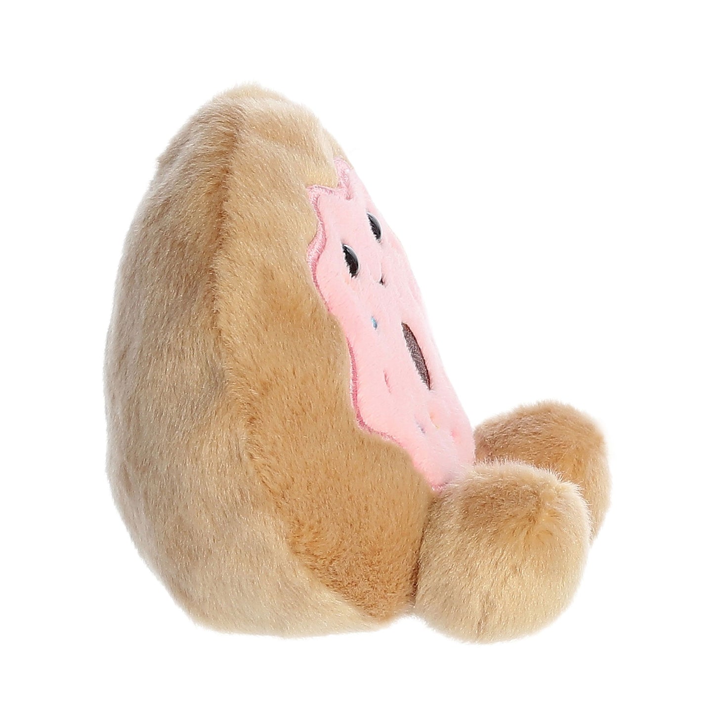 The Twice as Sweet Palm Pal Claire Donut is a plush toy shaped like a donut with pink frosting and sprinkles, soft brown fur, and two small round feet, shown from a side angle.