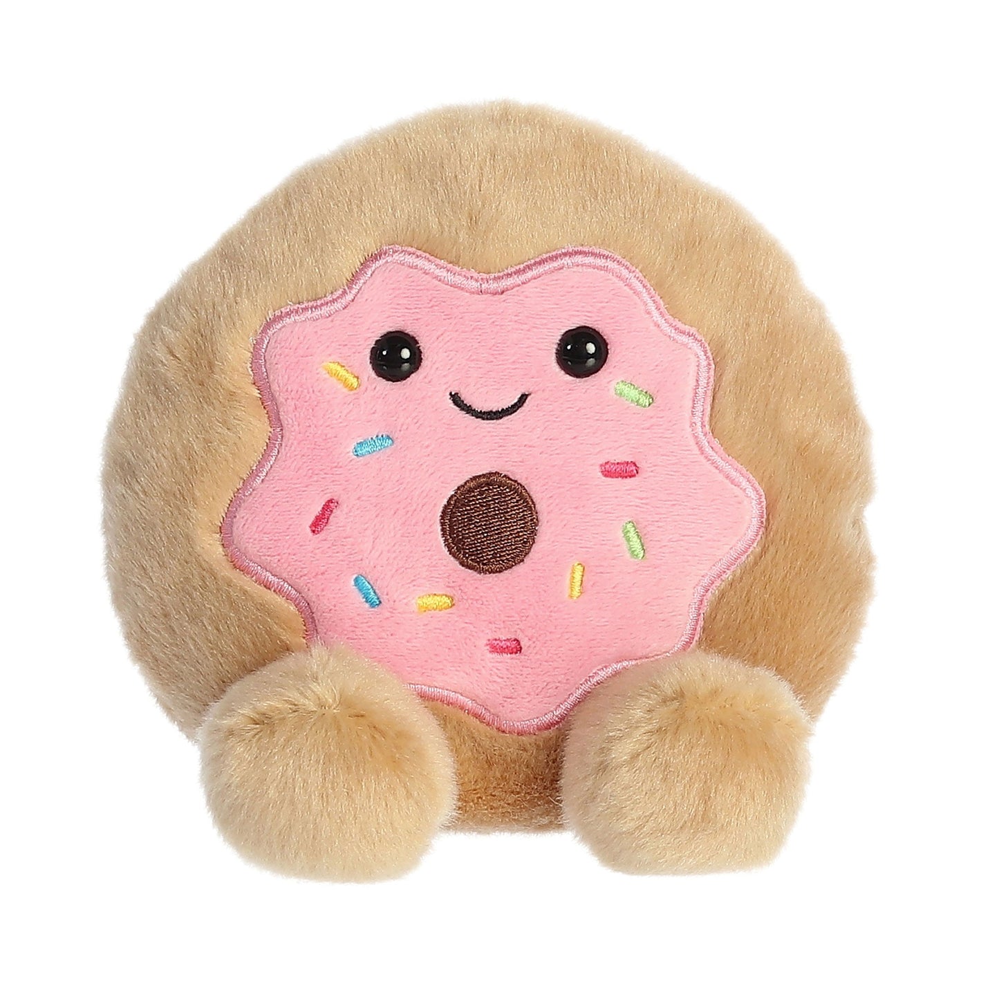 The Twice as Sweet Palm Pal Claire Donut is a plush toy with tan dough, a pink frosted top with colorful sprinkles, a smiling face, and two round fluffy feet.