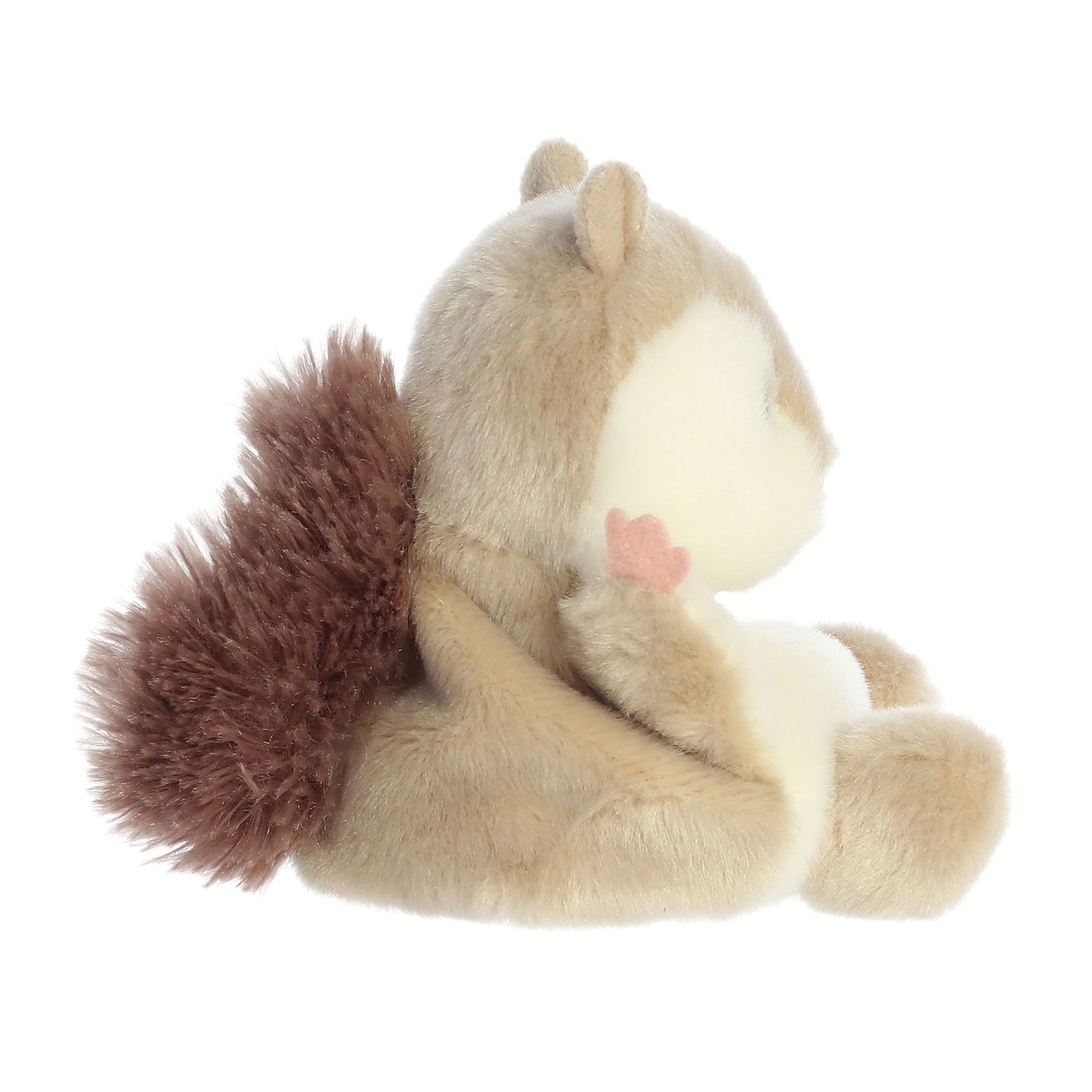 A side view of the Palm Pal Flaps Flying Squirrel plush toy by Twice as Sweet features light brown fur, a fluffy dark brown tail, a cream face and belly, and a small pink paw, sitting on a white background.
