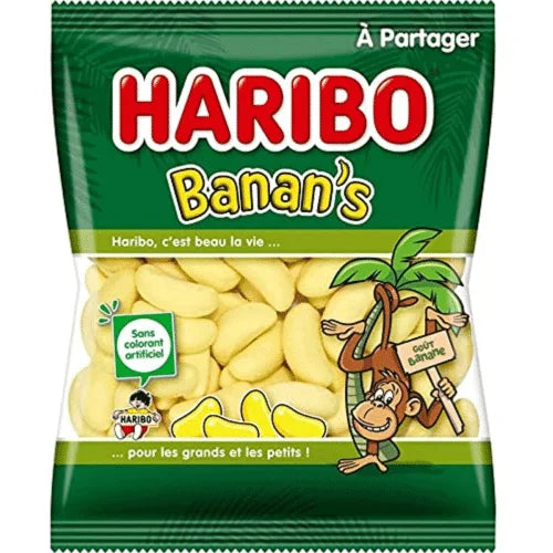 A green and yellow 300g bag of Twice as Sweet Haribo Bananas (France), with banana-shaped gummies, a cartoon monkey, and French text highlighting fruity banana flavor and no artificial coloring.