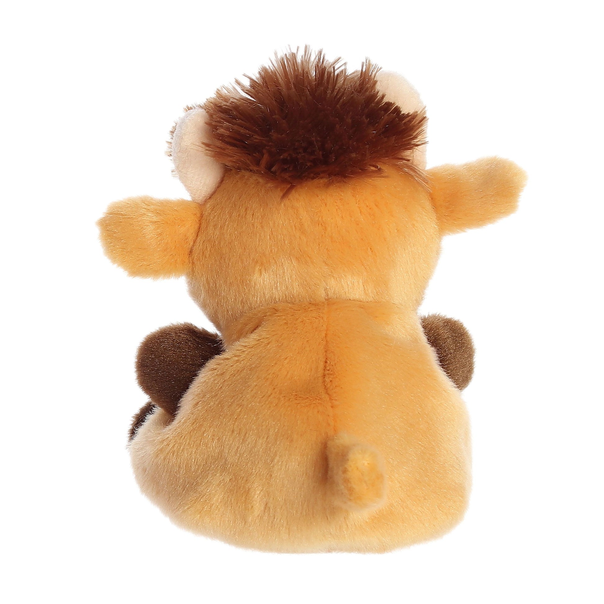 The Twice as Sweet Palm Pal Hubert Highland Cow plush is shown from the back, featuring tan and brown fur, a small tail, fluffy mane, and visible round ears and legs as it sits upright against a white background.