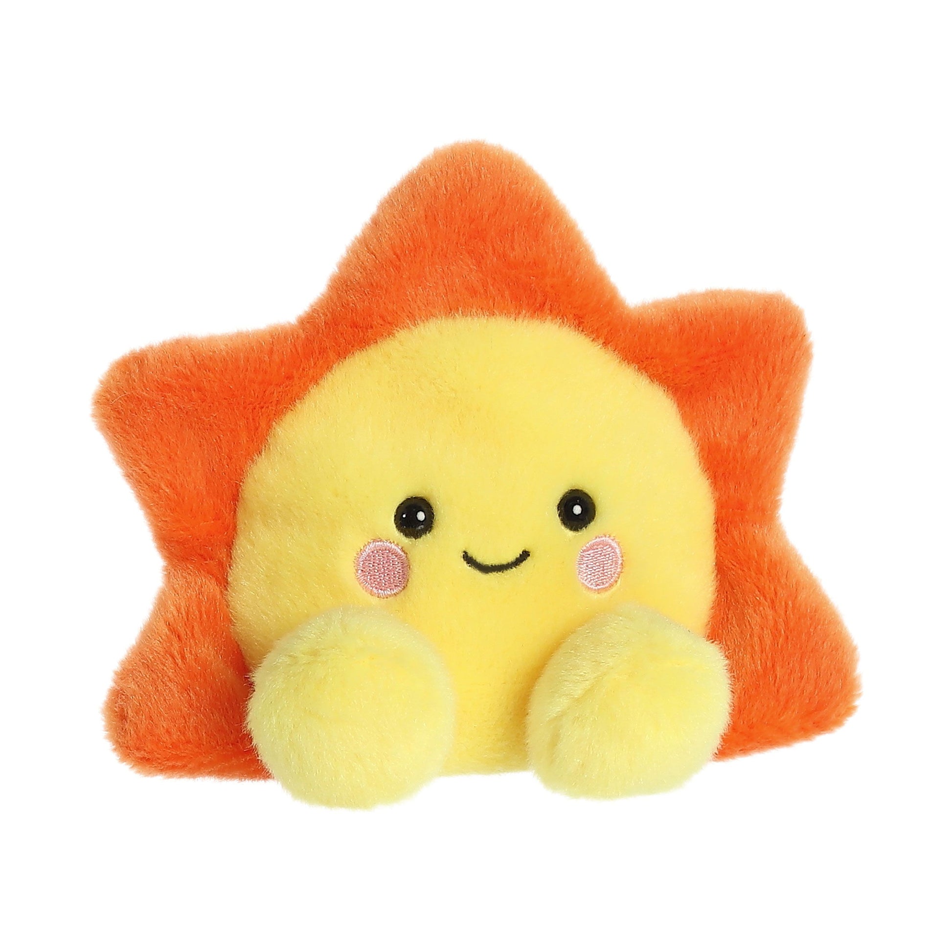 The Palm Pal Rae Sun by Twice as Sweet is a plush toy shaped like a smiling sun, featuring a yellow face, pink cheeks, black eyes, an orange sun-ray outline, and two yellow arms in front.