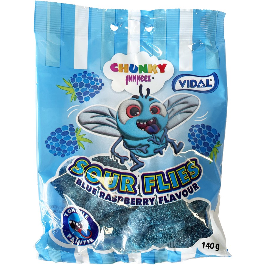 A blue and white bag labeled Vidal Sour Blue Raspberry Flies 140g (Spain) by Twice as Sweet features a cartoon fly and blue raspberry graphics, containing blue, sugar-coated sour gummies from the popular Spanish candy brand.