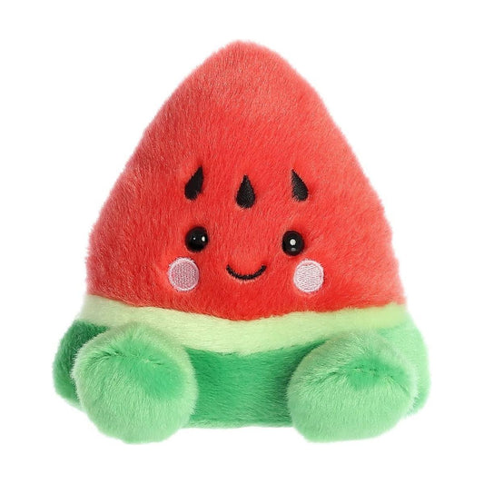 Bring cheerful vibes with the Palm Pal Sandy Watermelon by Twice as Sweet—a plush shaped like a watermelon slice, featuring a red top, green bottom, black seeds, round eyes, rosy cheeks, a smiling mouth, and soft green limbs.